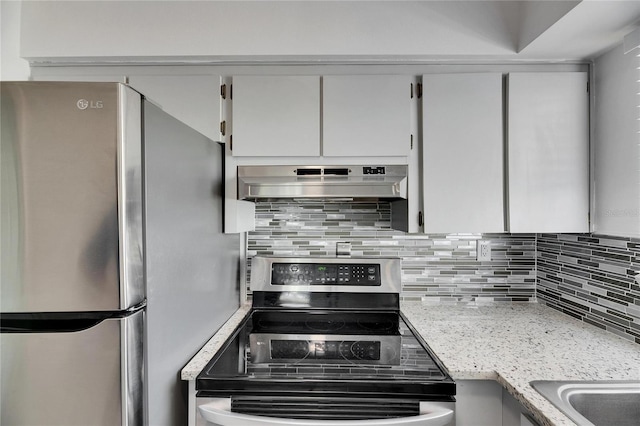 kitchen with appliances with stainless steel finishes, tasteful backsplash, and light stone counters