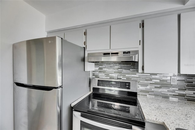 kitchen with exhaust hood, backsplash, appliances with stainless steel finishes, and light stone countertops