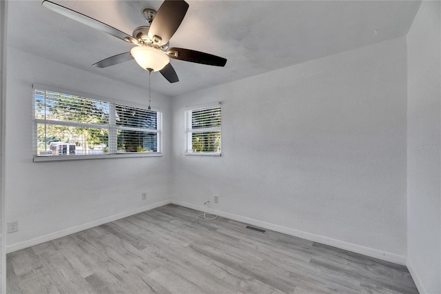 empty room with ceiling fan and light hardwood / wood-style flooring