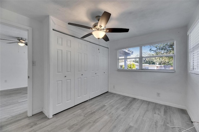 unfurnished bedroom with light wood-type flooring, a closet, and ceiling fan