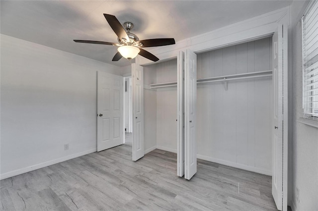 unfurnished bedroom featuring light hardwood / wood-style flooring, ceiling fan, and multiple closets