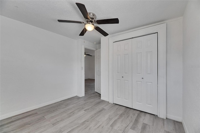 unfurnished bedroom featuring a textured ceiling, a closet, ceiling fan, and light hardwood / wood-style flooring