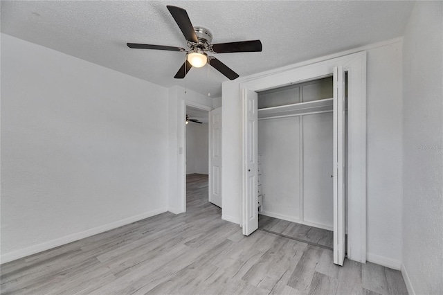 unfurnished bedroom featuring a textured ceiling, a closet, ceiling fan, and light hardwood / wood-style floors