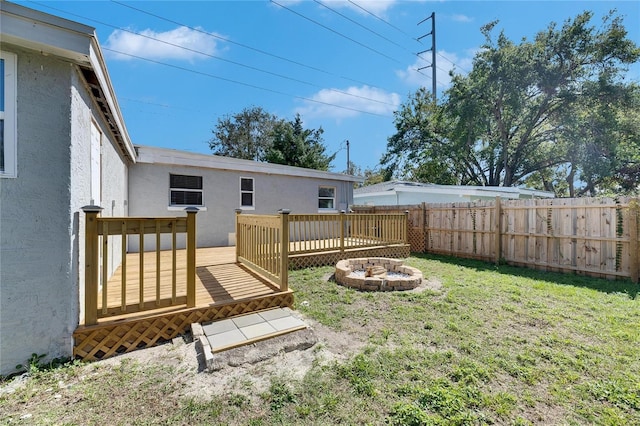 view of yard featuring a deck and a fire pit