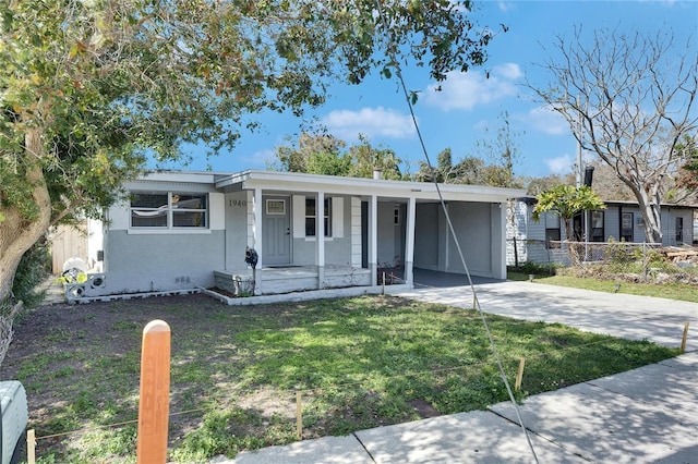 view of front of home with covered porch, a carport, and a front yard