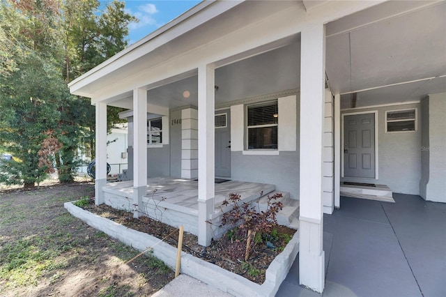 view of exterior entry featuring covered porch