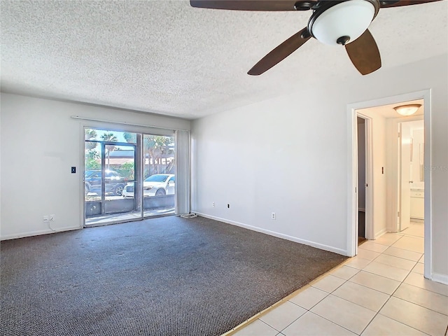 6312 Newtown Cir Unit 12A5, Tampa, FL 33615 - spare room featuring baseboards, light tile patterned flooring, a textured ceiling, and light colored carpet