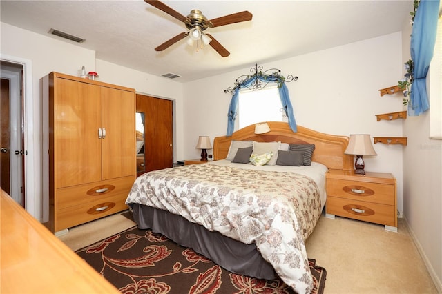 bedroom featuring visible vents, a ceiling fan, and light colored carpet