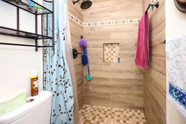 full bathroom with toilet and a tile shower