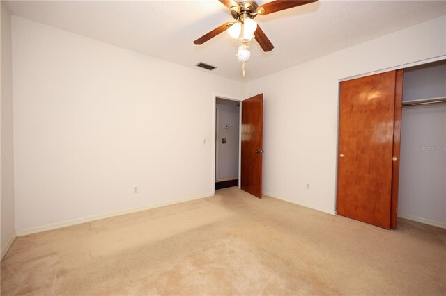 unfurnished bedroom with light carpet, baseboards, visible vents, a ceiling fan, and a closet