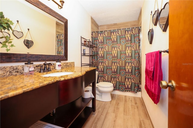 full bathroom with vanity, toilet, and wood finished floors