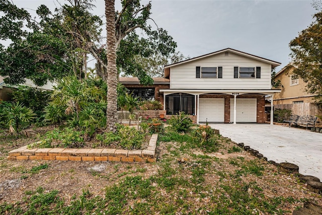 view of front facade featuring driveway, an attached garage, fence, and brick siding