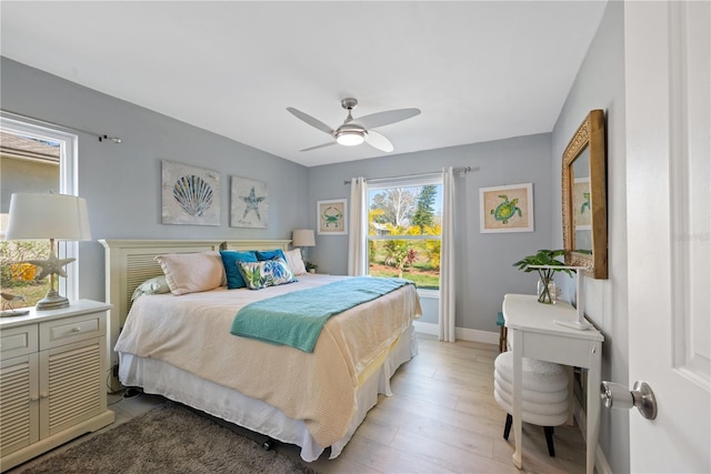 bedroom featuring a ceiling fan, light wood-type flooring, and baseboards