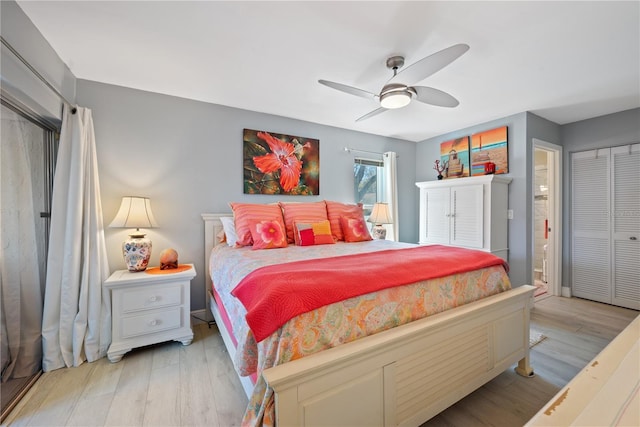 bedroom with light wood-style flooring, ceiling fan, and connected bathroom