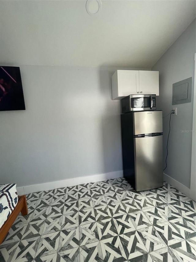 kitchen featuring white cabinetry, baseboards, electric panel, and appliances with stainless steel finishes