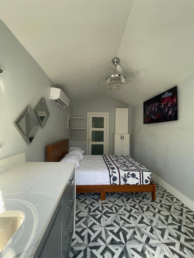 bedroom featuring baseboards, vaulted ceiling, an AC wall unit, light floors, and a sink