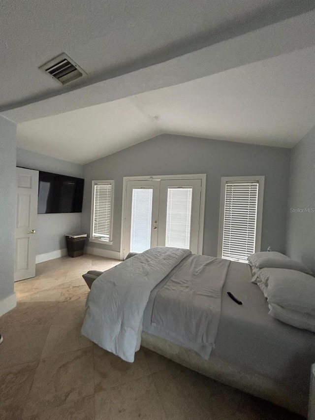 bedroom with lofted ceiling, baseboards, visible vents, and french doors