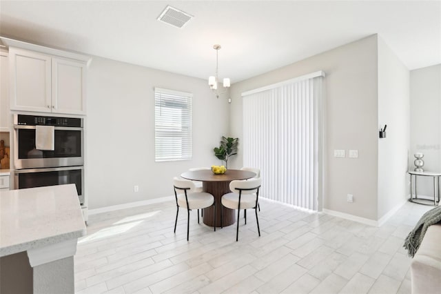 dining room with visible vents, a notable chandelier, and baseboards