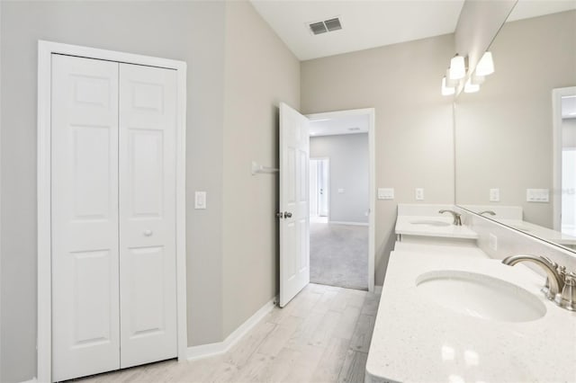 full bathroom with a sink, double vanity, visible vents, and a closet