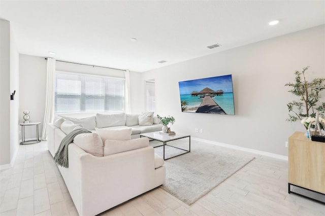 living room featuring recessed lighting, light wood-type flooring, visible vents, and baseboards