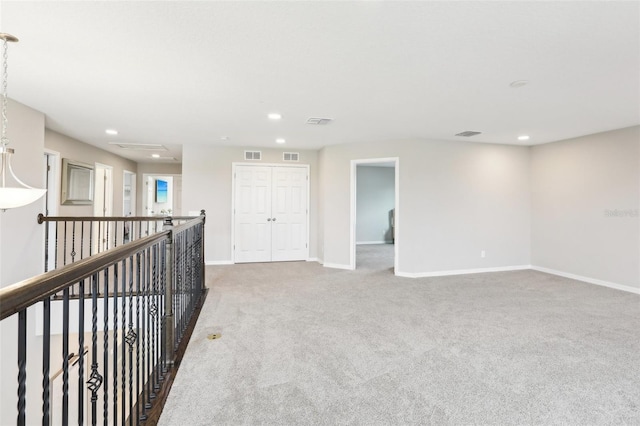 carpeted spare room featuring visible vents, baseboards, and recessed lighting