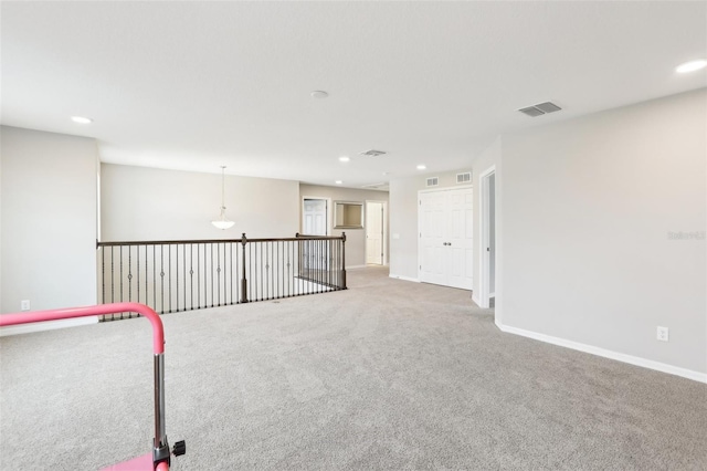 spare room featuring carpet floors, visible vents, baseboards, and recessed lighting