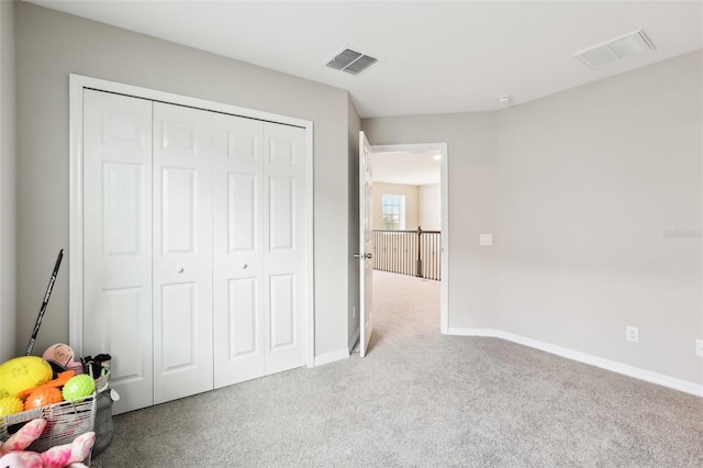 unfurnished bedroom featuring carpet, a closet, visible vents, and baseboards