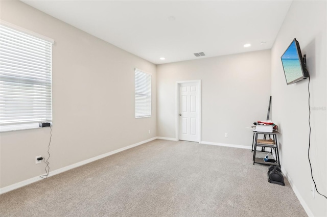 empty room with recessed lighting, baseboards, visible vents, and light colored carpet