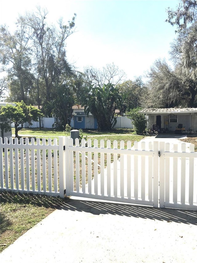 view of gate with a yard and a fenced front yard