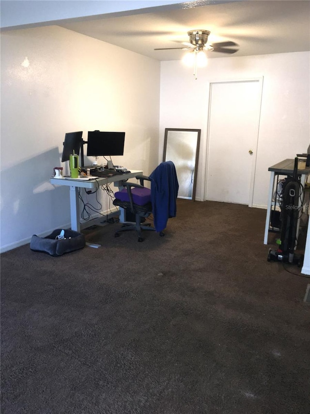 carpeted home office featuring ceiling fan