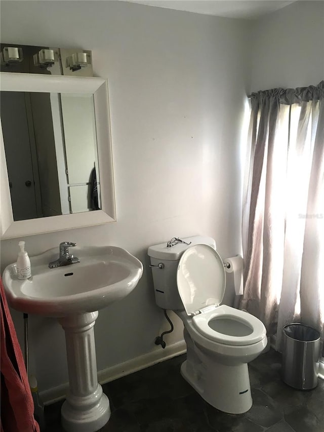 bathroom with baseboards and toilet