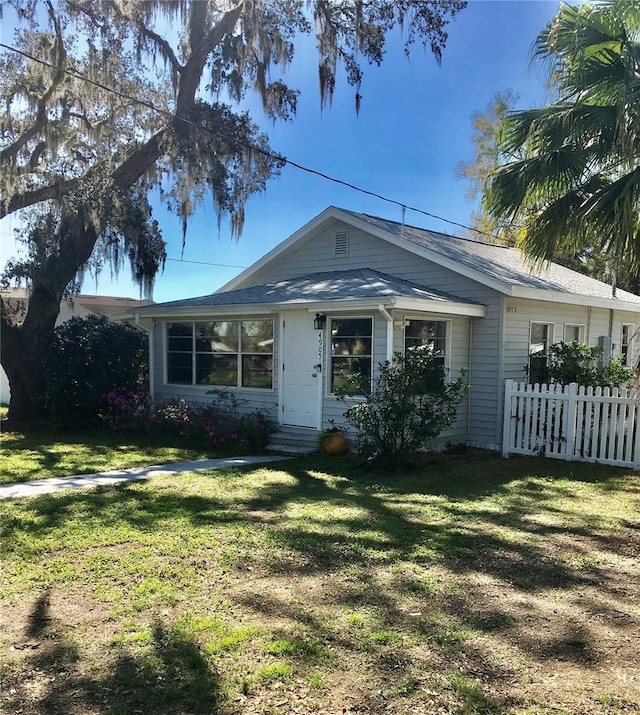 view of front of property featuring fence and a front lawn