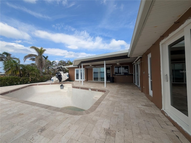 view of patio featuring an empty pool and a ceiling fan