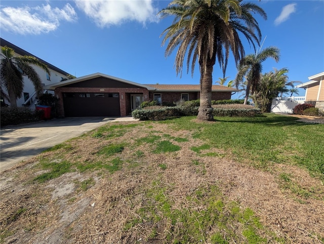 single story home featuring an attached garage, brick siding, concrete driveway, and a front yard