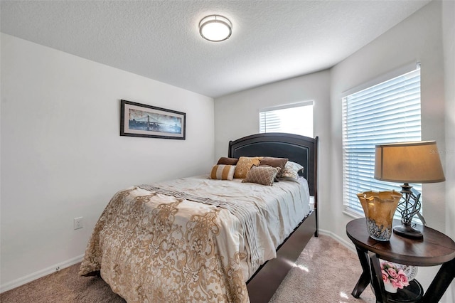 bedroom with a textured ceiling and light colored carpet