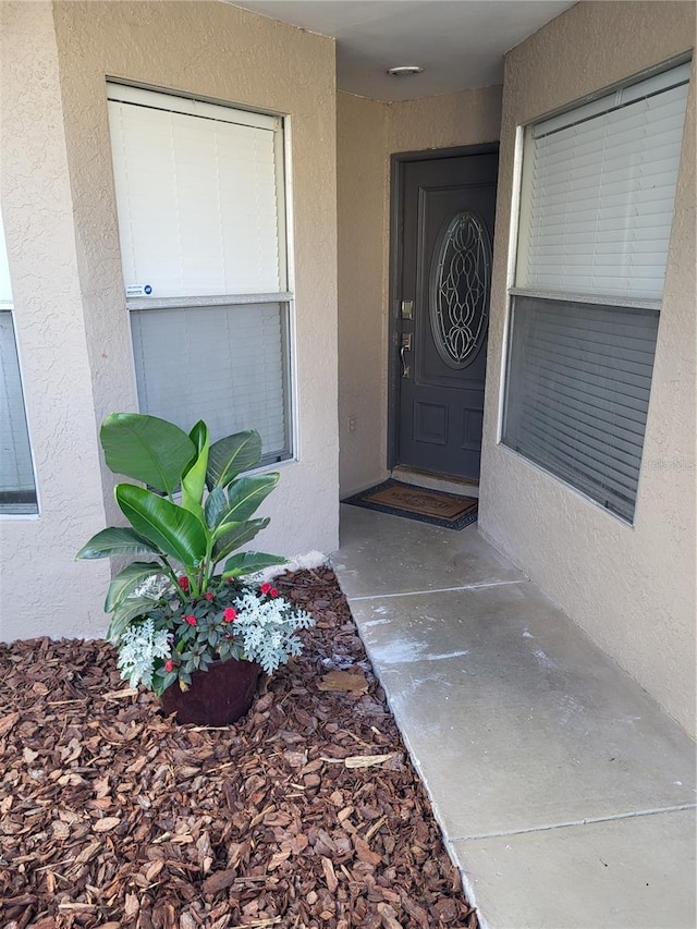 entrance to property featuring stucco siding