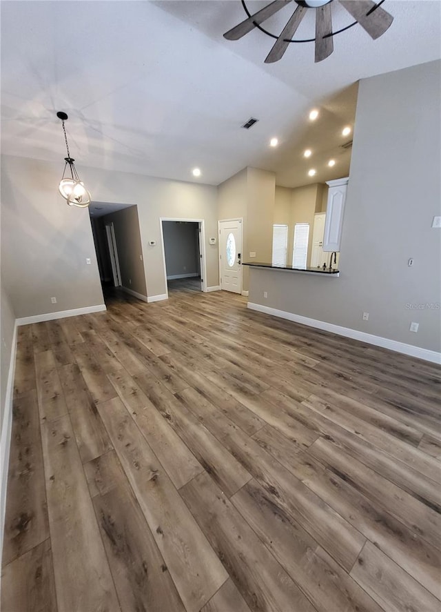 unfurnished living room featuring baseboards, visible vents, wood finished floors, and recessed lighting