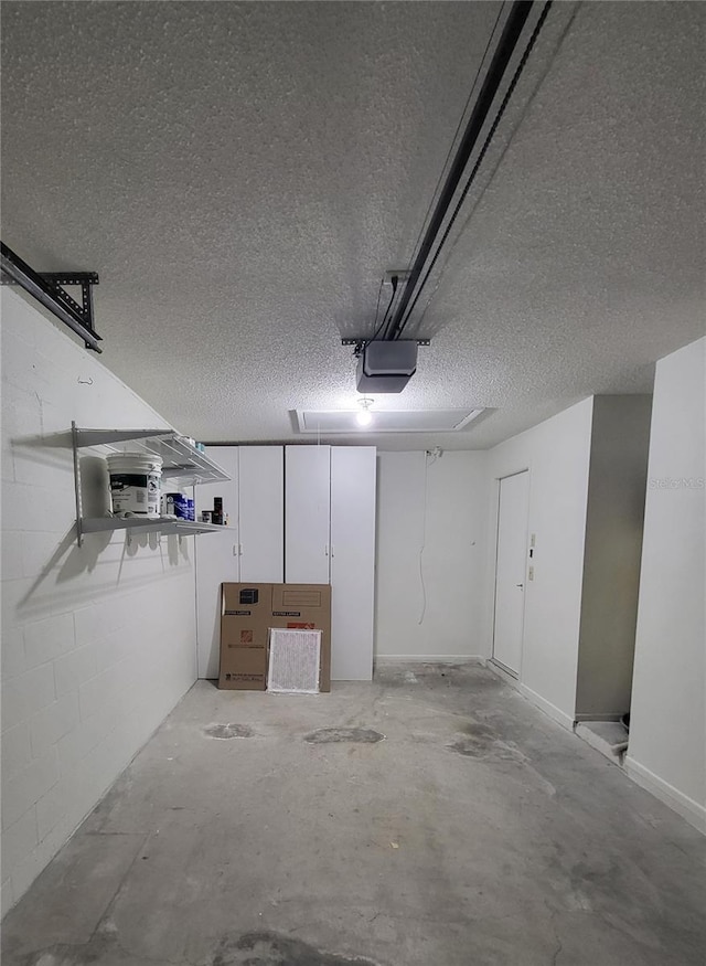 garage featuring concrete block wall and a garage door opener