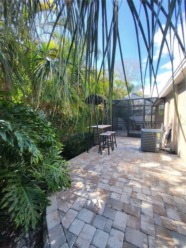 view of patio featuring a lanai and central AC unit