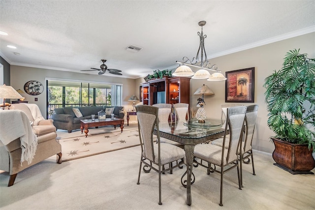 dining space with crown molding, visible vents, and light colored carpet