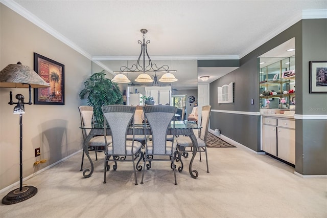 dining area featuring crown molding, baseboards, and light colored carpet