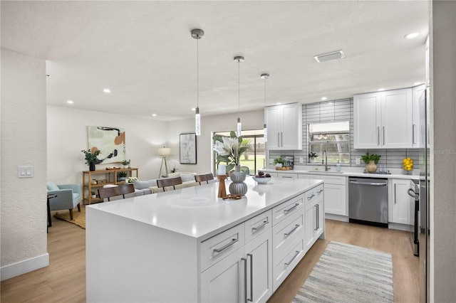 kitchen featuring a sink, light wood-style floors, white cabinets, and dishwasher