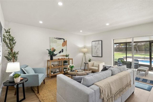 living room with light wood-type flooring, baseboards, and recessed lighting