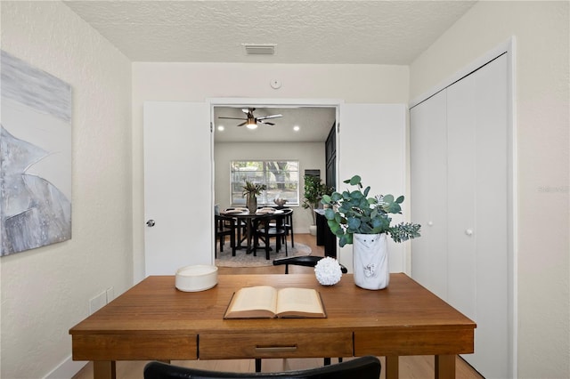 dining space with visible vents, a textured wall, and a textured ceiling