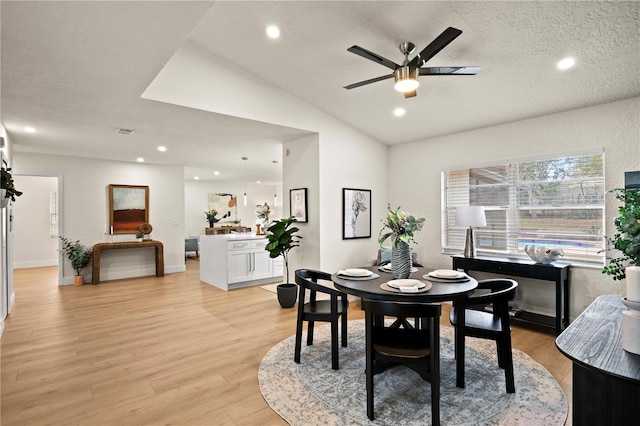 dining space with light wood finished floors, vaulted ceiling, and recessed lighting