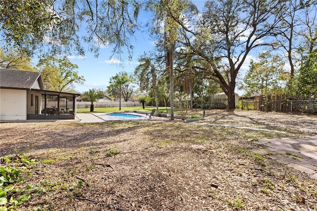 view of yard featuring a fenced in pool, a sunroom, a fenced backyard, and a patio