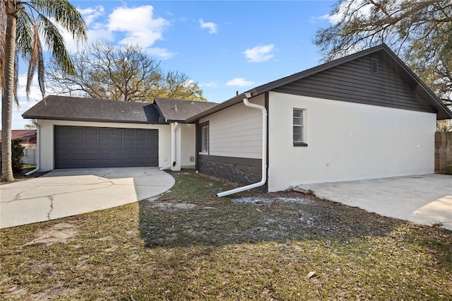 ranch-style home featuring concrete block siding, driveway, and an attached garage