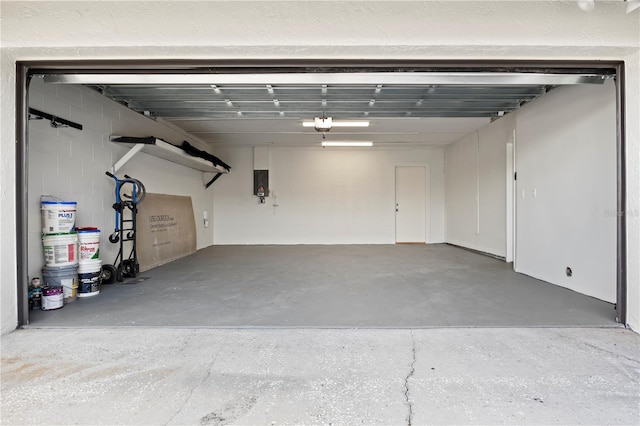 garage with concrete block wall and electric panel