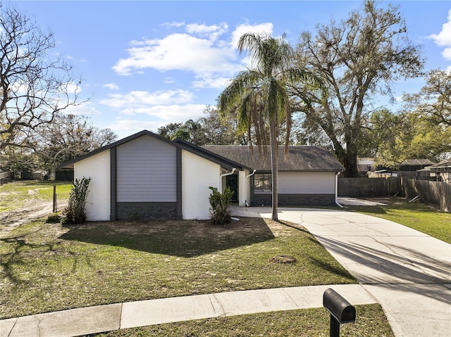 view of front of house with driveway, fence, and a front yard