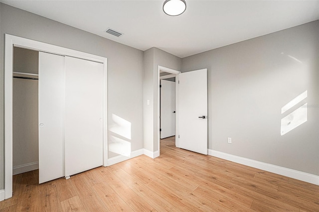 unfurnished bedroom featuring a closet and light hardwood / wood-style flooring